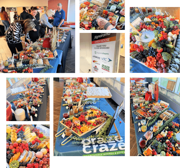 A table displays assorted fruits, nuts, cheeses, and snacks arranged on large charcuterie boards during an event.